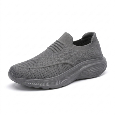 Grå, komfortable unisex-slip-on-sko med stødabsorberende sål og strækbart strikstof på hvid baggrund