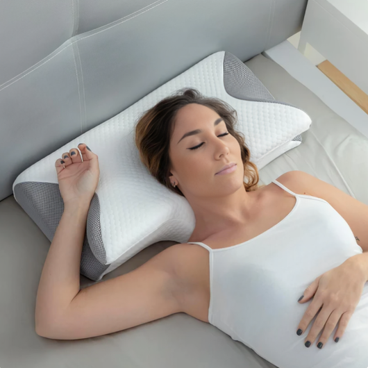 Kvinde, der sover på ryggen på en ergonomisk pude af hukommelsesskum med grå meshkanter