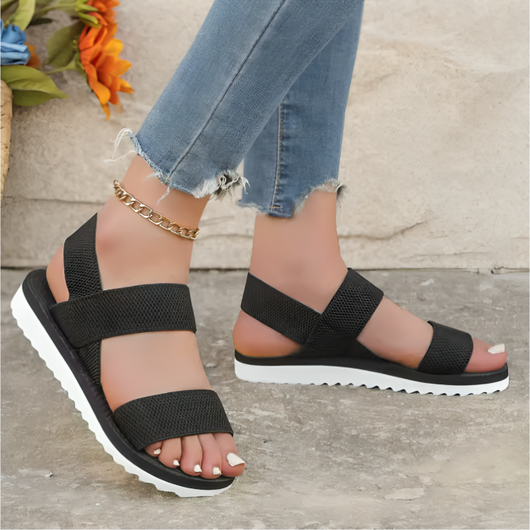 Sort: Elastiske mesh-sandaler med dobbelte remme i sort – Dame, set forfra med stenbaggrund