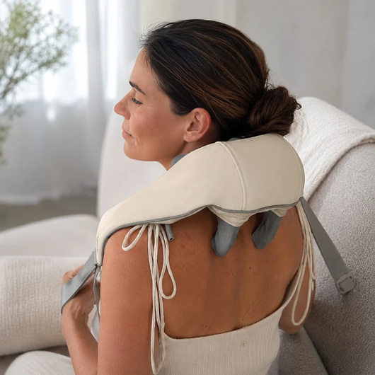 Kvinde med nakkemassageapparat set bagfra, stropperne bundet over skuldrene