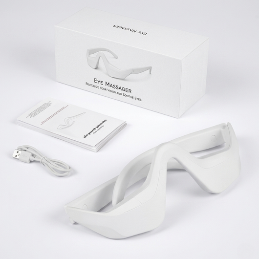 InfraRelief™ øjenmassager-produktpakke – hvid enhed, USB-opladerkabel, brugervejledning og emballage på hvid baggrund