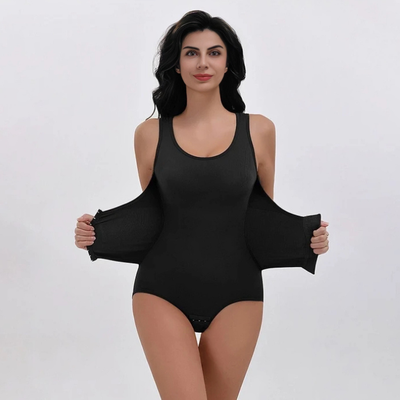 Kvinde viser det elastiske materiale på en sort figurformende body